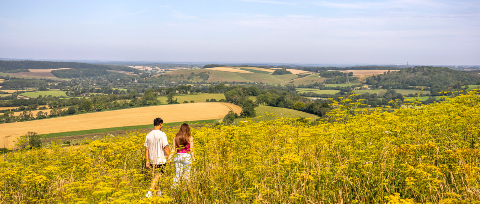 A couple walk on Butser Hill in the South Downs National Park
